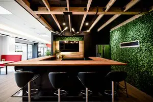 Fully equipped kitchen with coffee maker, refrigerator, and shared amenities for coworking members